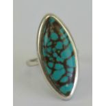 A silver and turquoise cocktail ring, the marquise cabachon of good green hue,