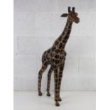 A fine floor standing African sculpture of a giraffe, leather covered with painted spots,