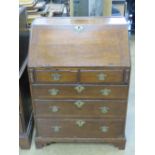 A good short late Georgian oak fall front bureau having two short over three long graduating