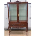 A 1930s walnut glazed display cabinet having twin glass shelves within and silk lined back,