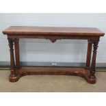 A rosewood buffet serving table raised over carved pillars united by an inverted solid base,