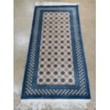 A Chinese woollen rug, blue and cream ground having label upon and measuring 172 x 78cm.