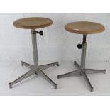 Industrial school; two X based metal stools each with adjustable circular tops,