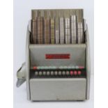 An International Cashier coin counting machine model W100 734 with dust cover and a quantity of pre