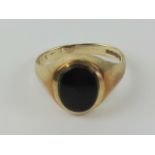 A 9ct gold and onyx signet ring, unengraved oval stone, hallmarked 375, size M, 2.