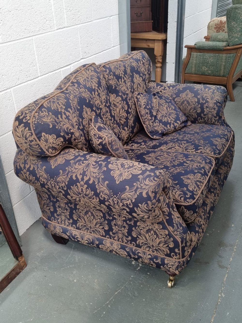 A two seater settee having scroll arms and upholstered in blue and gold fabric, loose cushions, - Image 2 of 2