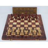 A contemporary travel chess set having carved wooden pieces within.