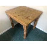 A square shaped Victorian style pine table raised over turned legs, single drawer under,