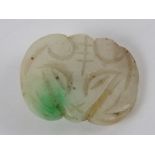 A single jade button 'mutton fat' white with green fleck carved in the form of a rams head, 1.