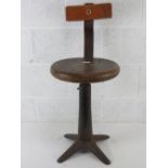 A pine top Singer (sewing machine) stool with sprung back and quatreform base, seat 35cm dia,