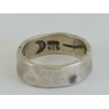 A Mary Cayatineto Navajo hand planished silver ring having Native American symbols within,