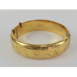 A vintage English made rolled gold hinged bangle having floral engraving to front, 6cm internal dia,