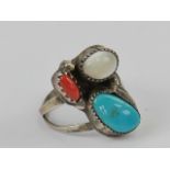 A Native American ring having turquoise mother of pearl and coral set in white metal,