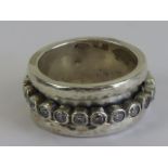 A worry ring (stress ring / fidget ring) having central white stone set rotating band,
