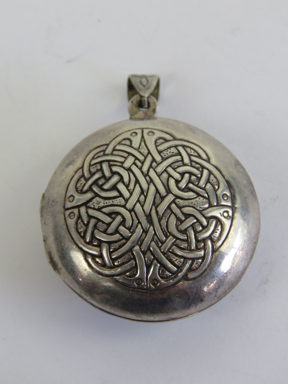 A large HM silver Celtic locket having Irish blessing and knot design upon 'May the road rise to