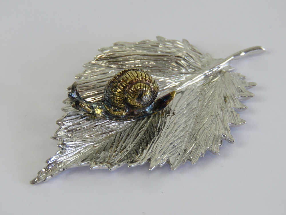 An unusual and superbly made HM silver ornament in the form of a gilded snail upon a leaf,