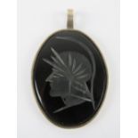 A large carved onyx pendant having Roman Centurion upon in HM silver frame, measuring 5.