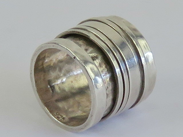 An unusually wide handmade worry ring (stress ring / fidget ring) having five rotating central