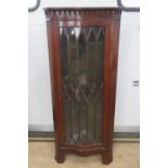 A 20th century astral glazed freestanding corner cabinet in mahogany, glazed door opening to