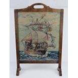 A vintage fire screen having Naval themed wool work within, 49cm wide, 74.5cm high.