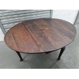 An oval drop leaf table raised over shaped legs, 5ft x 4ft x 2ft 4''.