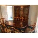 An oval Yew wood extending dining table (196 x 91cm extended) raised over twin pedestals, with six