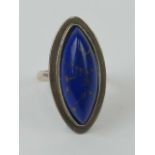 A lapis lazuli cocktail ring, the large marquise shaped cabachon having good gold coloured veining