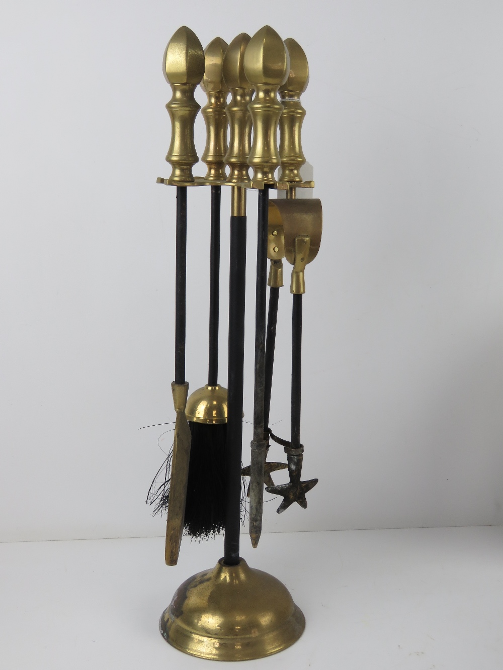 A brass and black painted metal fireside companion set comprising stand, brush, pan, poker and