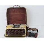 A vintage Olympia typewriter in case. Together with a Voigtlander Vito II camera in pigskin