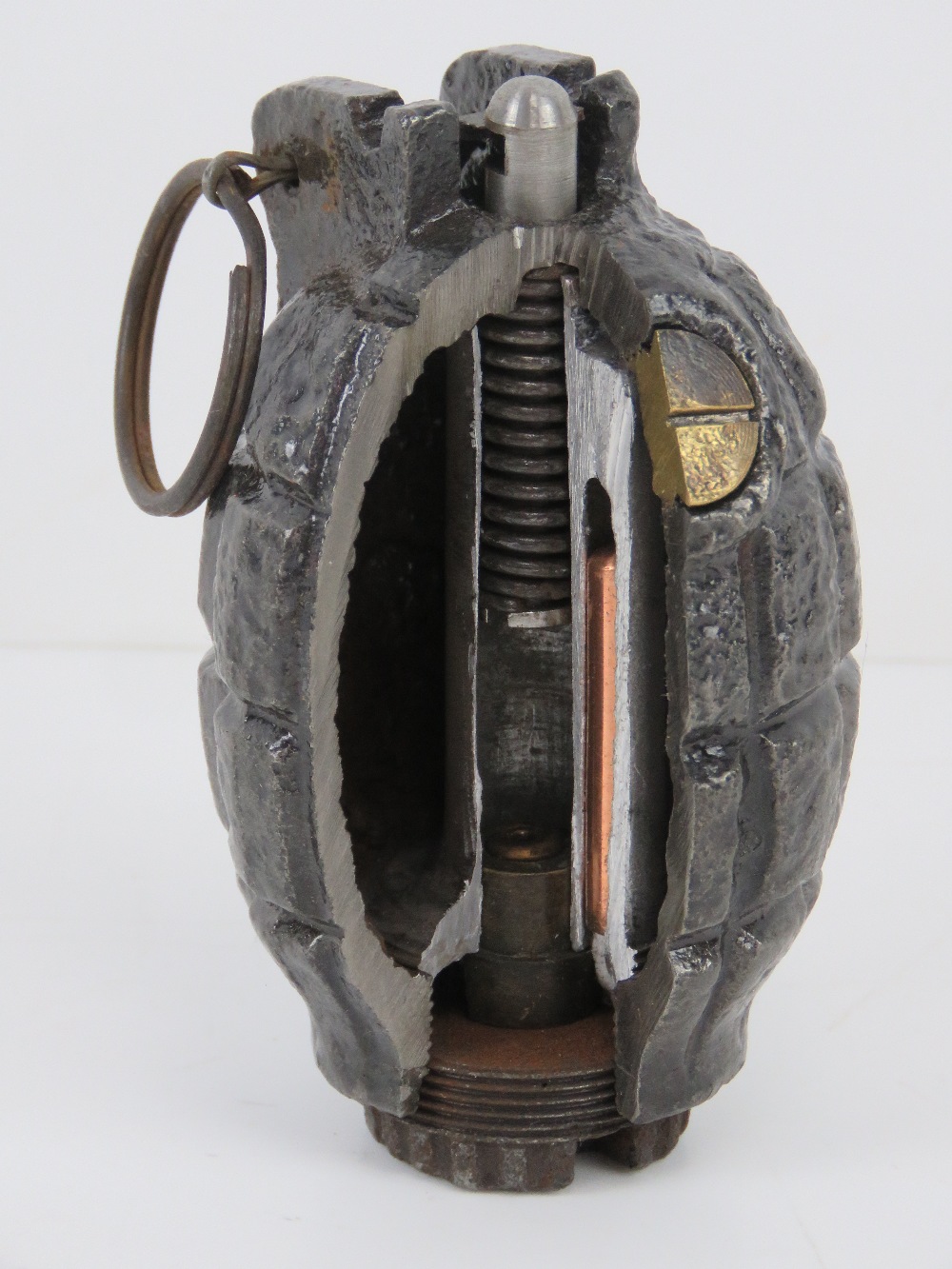 An inert WWI Mills No.36 grenade having cut away section for display, with spoon and pin.