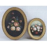 Two mid 20thC oil on canvas floral still life paintings in matched oval frames,