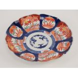 An Oriental dish decorated in blues and reds having fluted border, 21cm dia,