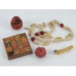 An Oriental wooden fifteen piece captive puzzle, two carved Oriental gourds, a shell 'caterpillar',