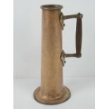 An Arts & Crafts 'trench art' style copper jug with wooden handle standing 31cm high.