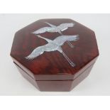 A high lacquer Oriental jewellery box of octagonal form having inset mother of pearl cranes or