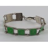 A sterling silver bracelet having floral design green enamelled panels, enamel slightly a/f, 18.