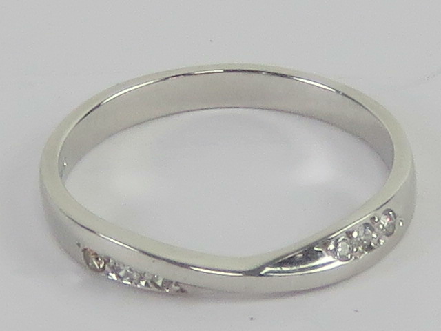 A platinum and diamond ring, central twist flanked by three round cut brilliant diamonds,
