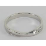 A platinum and diamond ring, central twist flanked by three round cut brilliant diamonds,
