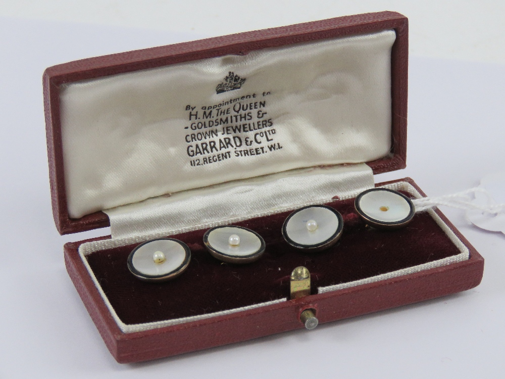 A pair of 9ct gold mother of pearl and seed pearl cuff links presented within Garrard & Co Ltd box,