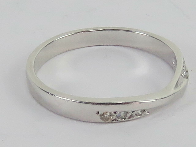 A platinum and diamond ring, central twist flanked by three round cut brilliant diamonds, - Image 3 of 3