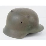 A WWII German M42 helmet having two holes caused by single bullet, original liner (a/f).