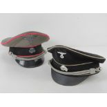 Two reproduction WWII German peaked caps being SS Officer's cap and Allgemeine Officer's cap.