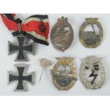 A quantity of reproduction WWII German medals and badges inc Iron cross. Seven items.