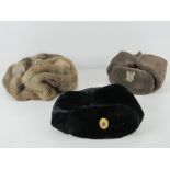 Three Russian winter hats, one bearing Soviet Military label upon,