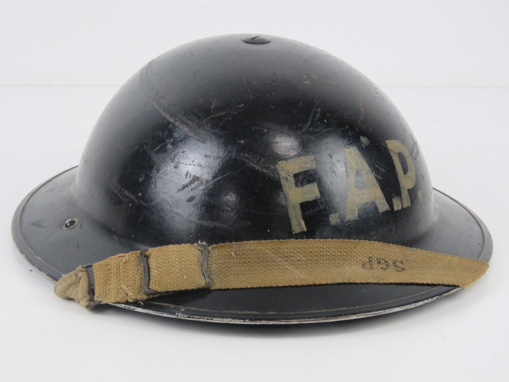 A WWII Brodie helmet FAP (First Aid Post) with liner and chinstrap.