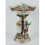 A large Capodimonte style centrepiece pedestal fruit bowl having two figures upon,