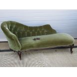 An Edwardian button back chaise lounge raised over shaped and scrolled legs.