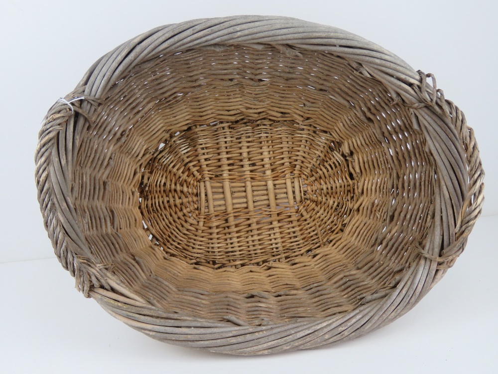 A wicker log basket of oval form having twin handles, measuring 59cm wide. - Image 3 of 3