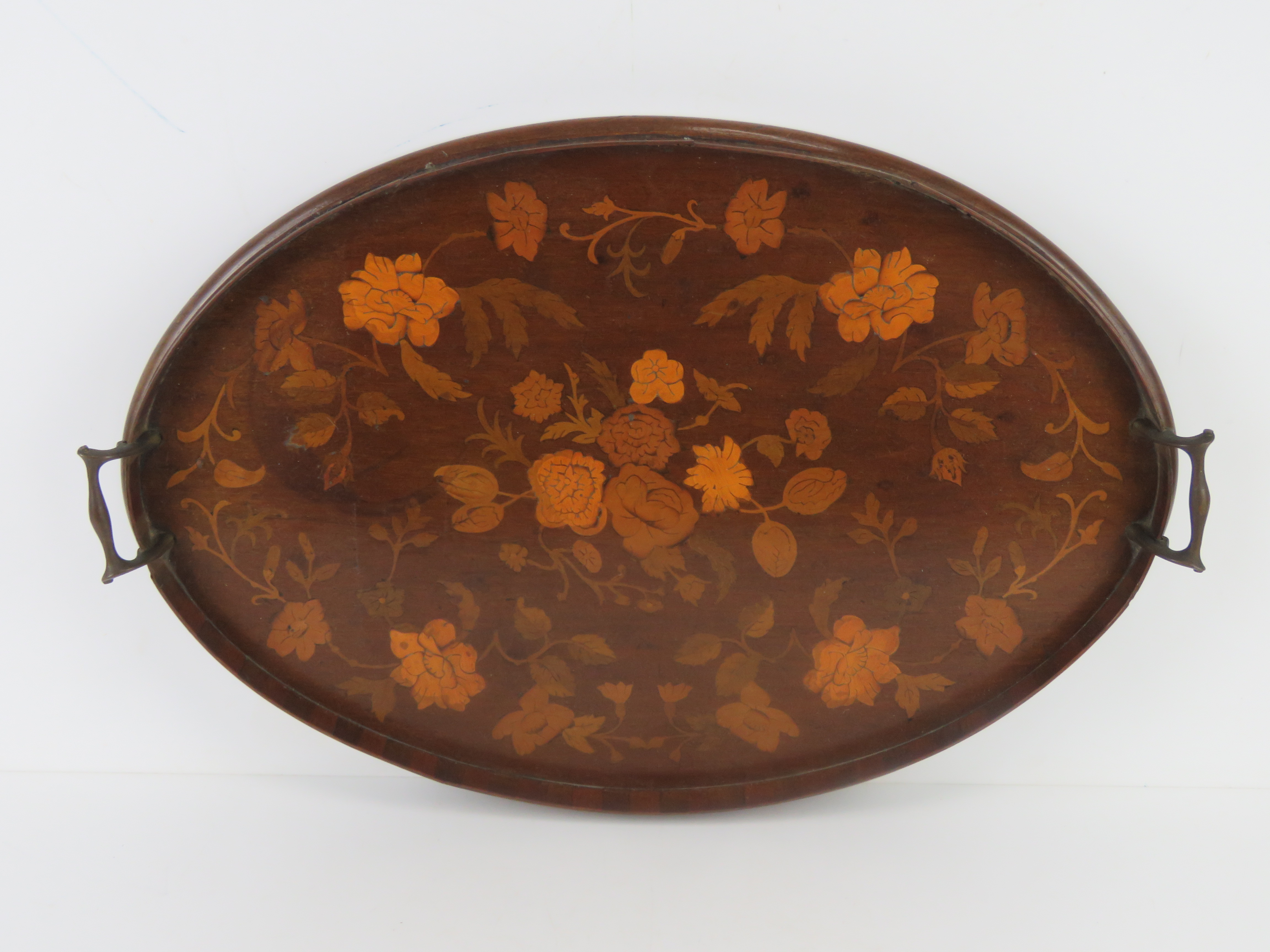 An inlaid mahogany serving tray having intricate floral design, brass end handles,