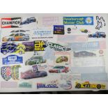 A large quantity of assorted motor racing themed bumper stickers, window stickers etc.